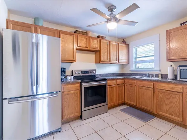 a kitchen with stainless steel appliances granite countertop a refrigerator a sink a stove and island