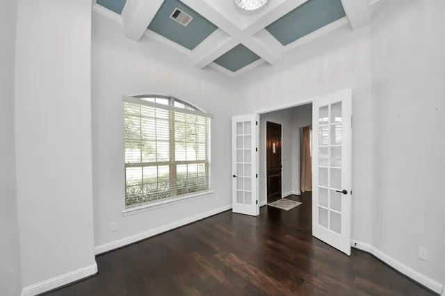 a view of an empty room with wooden floor and closet