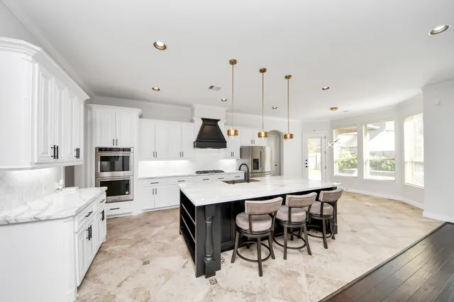 a kitchen with kitchen island a dining table and chairs