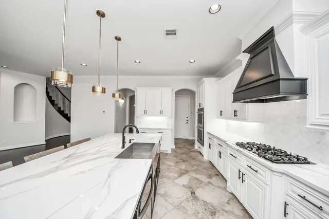 a kitchen with stainless steel appliances kitchen island granite countertop a stove a sink and a refrigerator