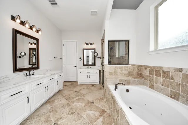 a bathroom with a bathtub sink and mirror