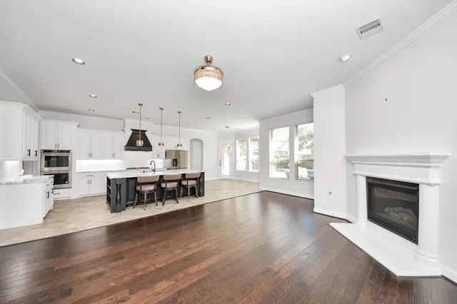 a living room with furniture a fireplace and wooden floor