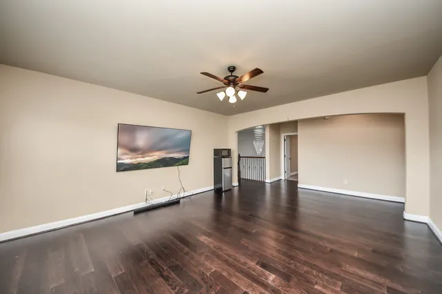 a view of an empty room with window and wooden floor