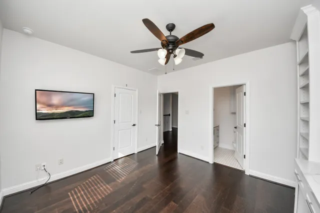 a view of a livingroom with wooden floor and a ceiling fan