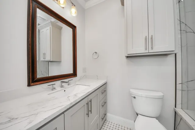 a bathroom with a toilet sink and mirror