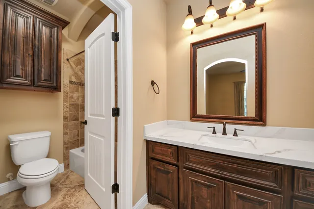 a bathroom with a toilet sink and mirror