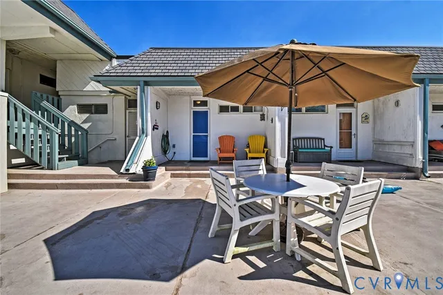 a view of patio with chairs and table under an umbrella