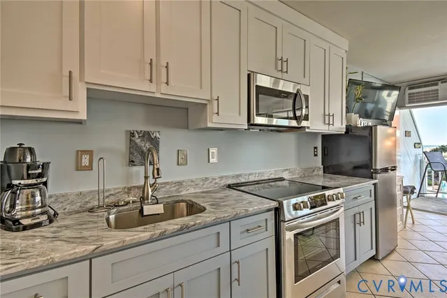 a kitchen with granite countertop a sink stove and microwave