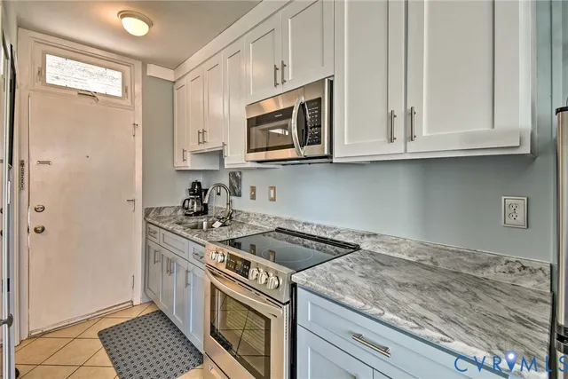 a kitchen with stainless steel appliances granite countertop a sink stove and microwave