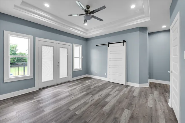 en empty room with wooden floor and ceiling fan