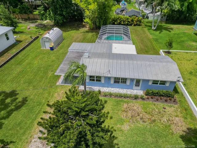 an aerial view of a house with swimming pool garden and patio