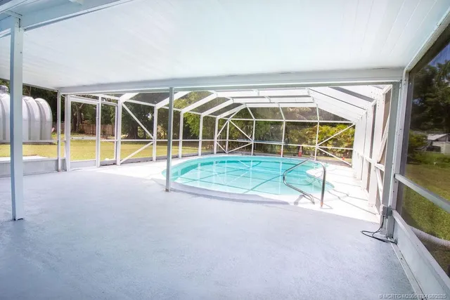 an empty room with floor to ceiling window and pool table