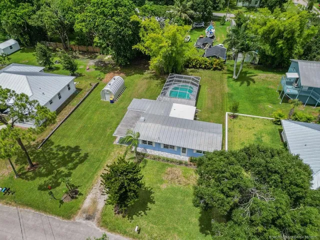 an aerial view of a house with a garden and lake view