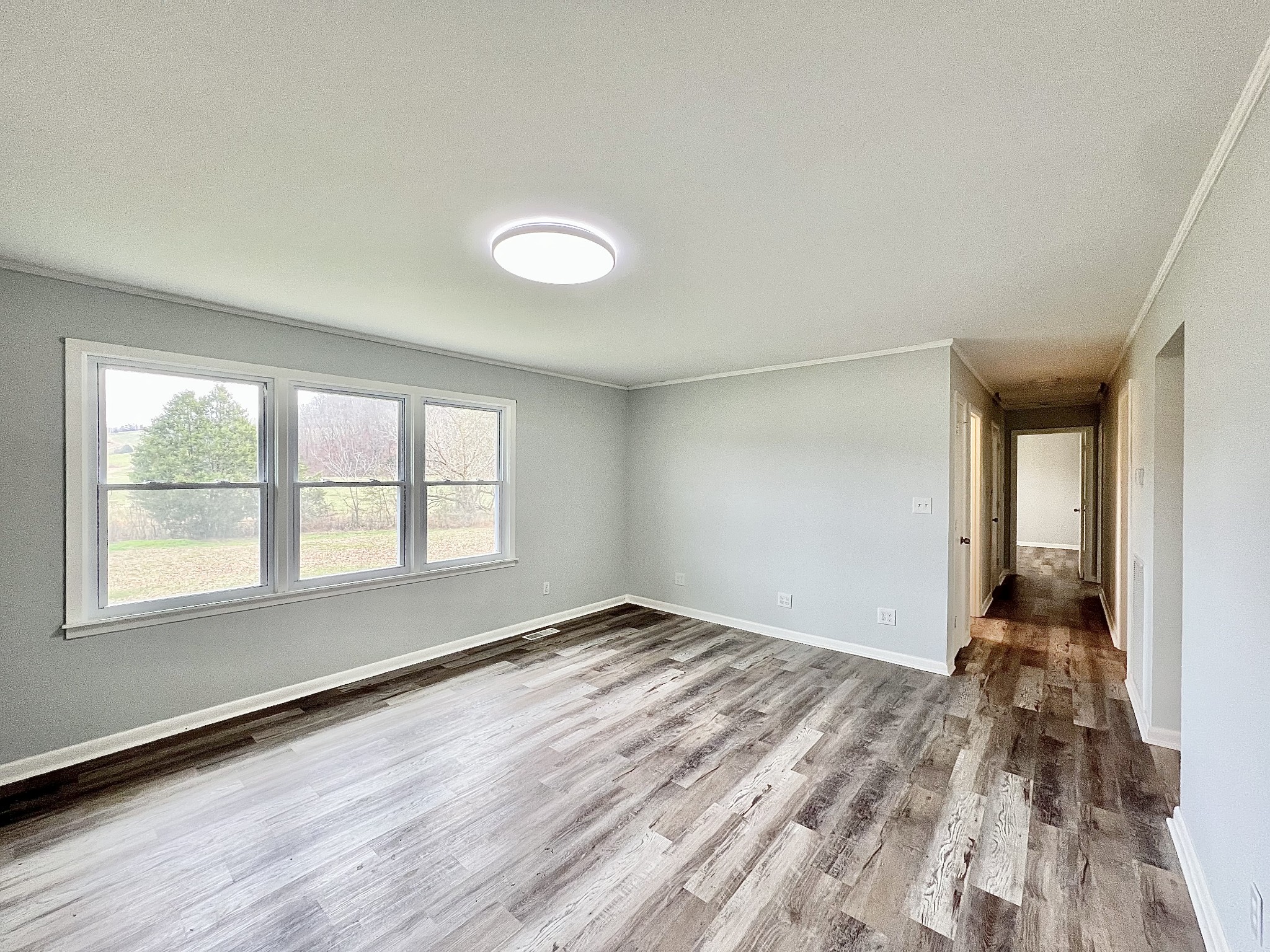 1595 Hurricane Creek Road Lawrenceburg, TN 38464 - Photo 16 of 74 an empty room with wooden floor and windows