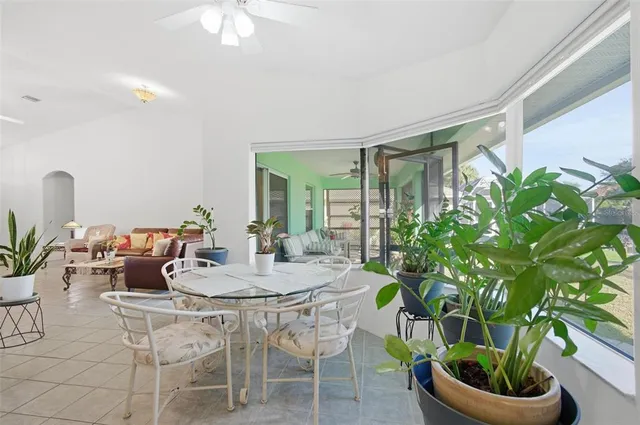 a bedroom with a bed a chair and a large window