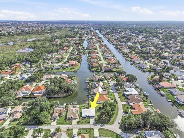 an aerial view of a house with a yard and lake view