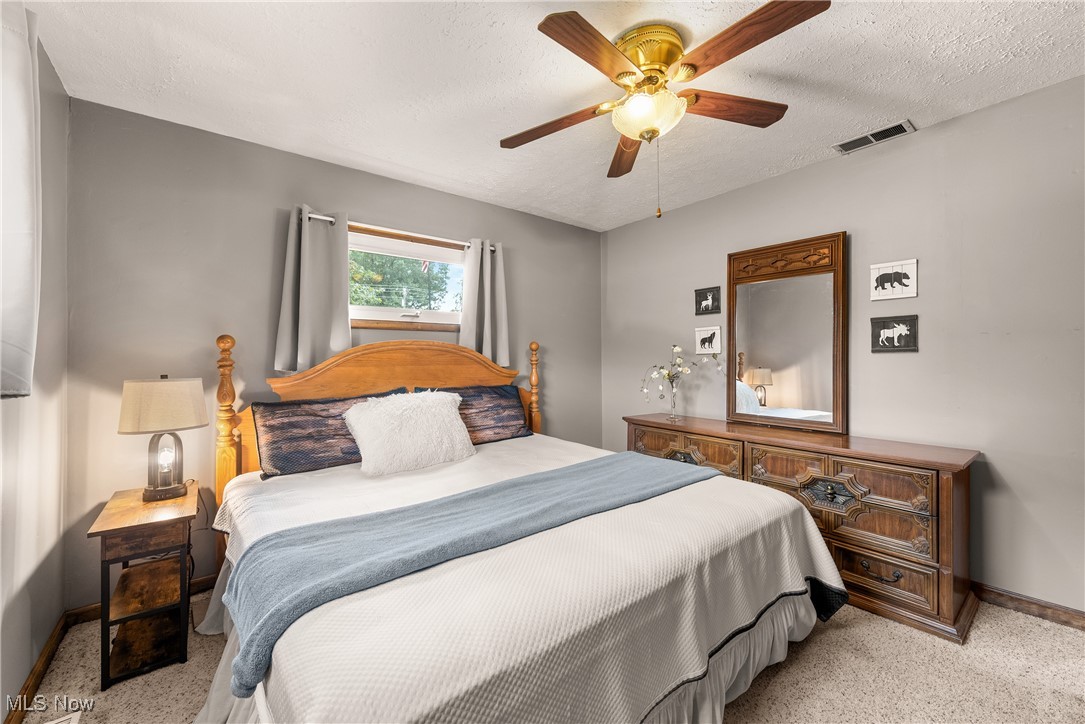 14808 Wheeler Road Lagrange, OH 44050 - Photo 25 of 50 Bedroom featuring a textured ceiling, a ceiling fan, and light colored carpet