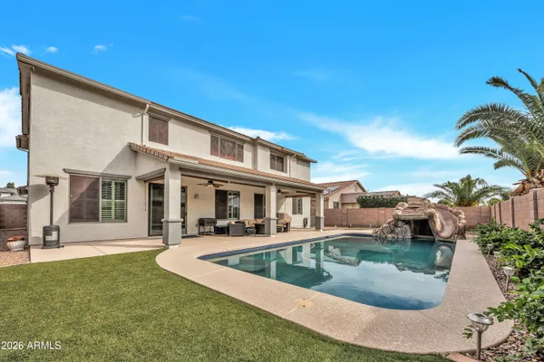 a view of a house with swimming pool and sitting area