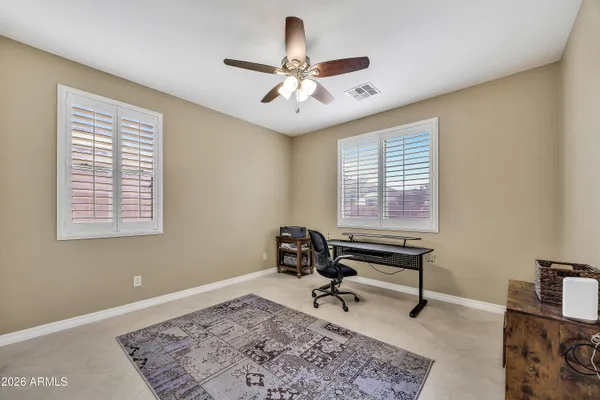 a room with chandelier fan and windows