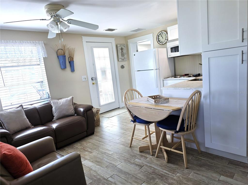 470 South McCall Road, Unit 11 Englewood, FL 34223 - Photo 11 of 22 a living room with furniture a refrigerator and a chandelier