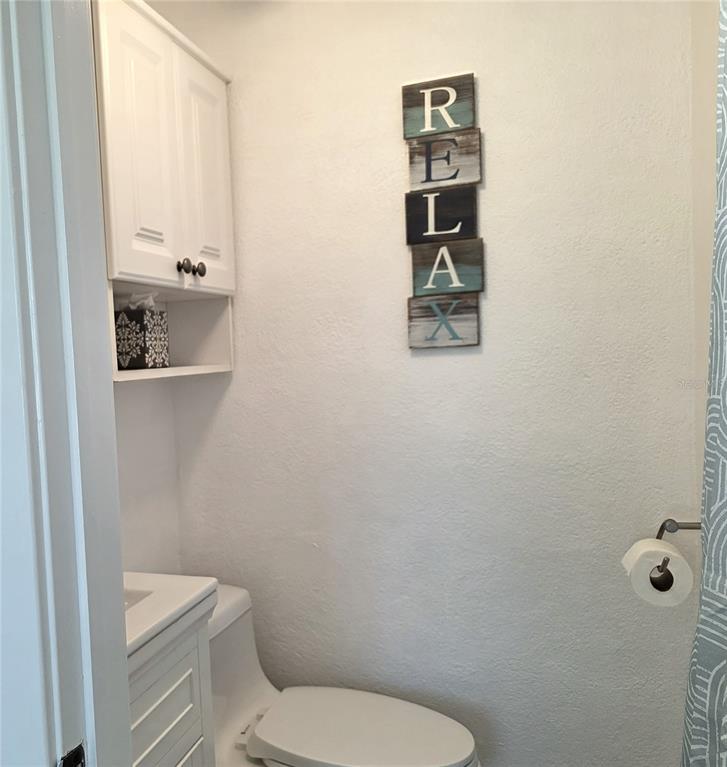 470 South McCall Road, Unit 11 Englewood, FL 34223 - Photo 21 of 22 a white toilet sitting next to a bathroom sink