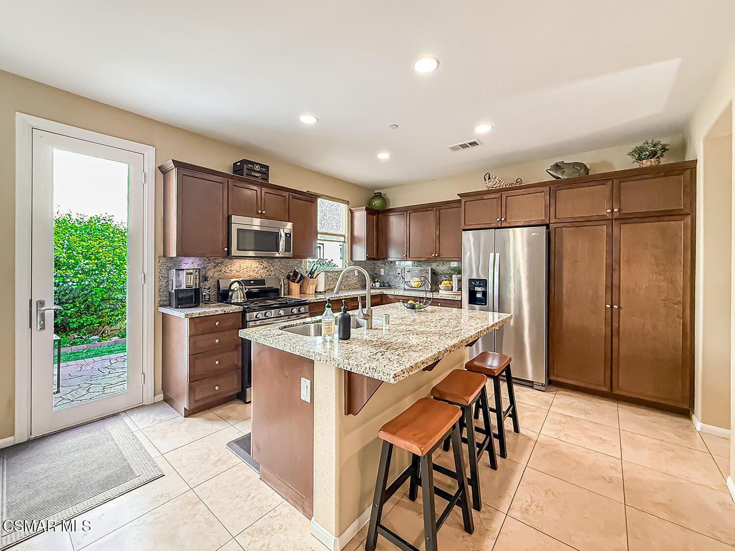 2968 Royal Avenue Simi Valley, CA 93065 - Photo 11 of 45 a kitchen with stainless steel appliances granite countertop a refrigerator a stove a sink a dining table and chairs