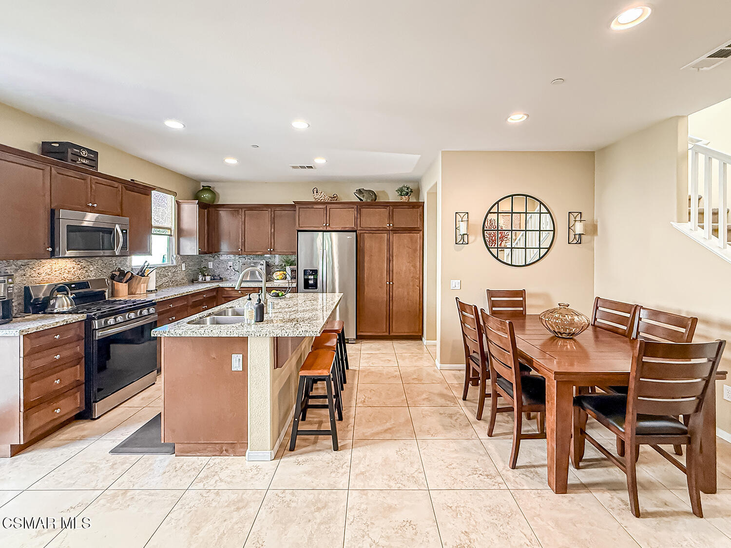 2968 Royal Avenue Simi Valley, CA 93065 - Photo 9 of 45 a kitchen with stainless steel appliances kitchen island granite countertop a table chairs and a refrigerator