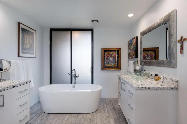 a bathroom with a tub a sink and mirror