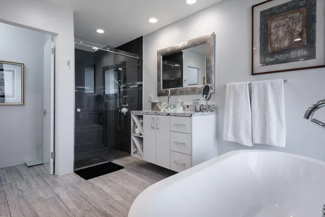 a bathroom with a double vanity sink mirror and shower