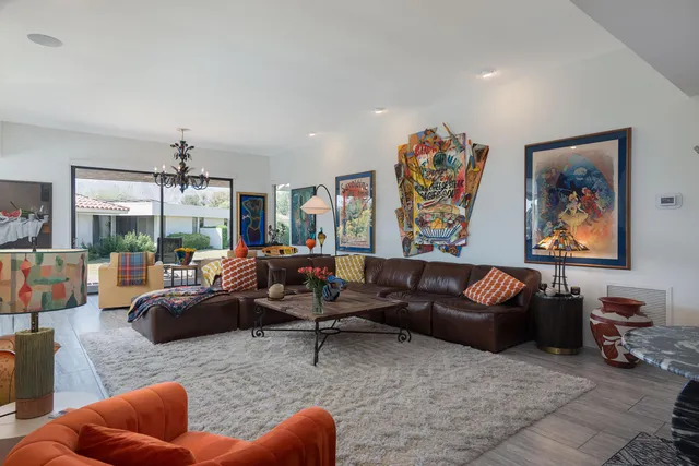 a living room with furniture a couch and a large window