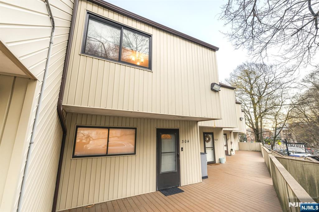 a view of a house with a barbeque and wooden stairs