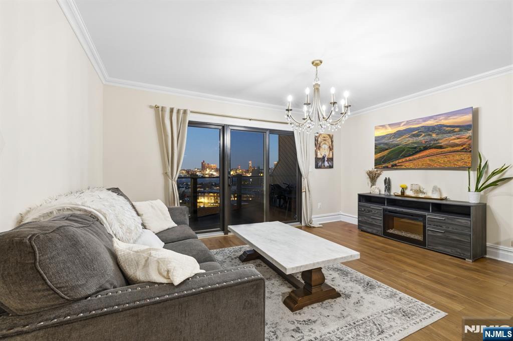 101 Highway 5, Unit 304 Edgewater, NJ 07020 - Photo 11 of 24 a living room with furniture and a chandelier