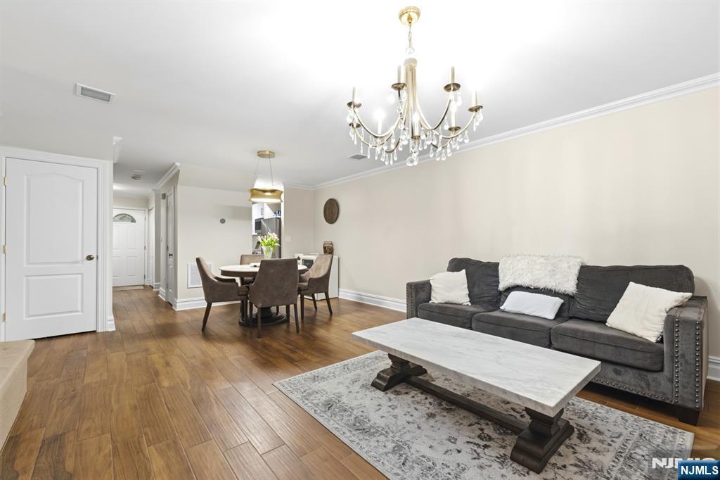 101 Highway 5, Unit 304 Edgewater, NJ 07020 - Photo 13 of 24 a living room with furniture and a chandelier