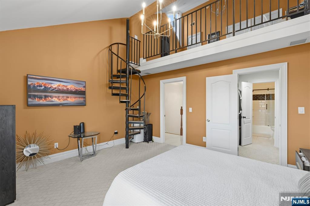 101 Highway 5, Unit 304 Edgewater, NJ 07020 - Photo 16 of 24 a bedroom with a bed and a chandelier