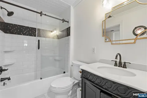 a bathroom with a sink toilet vanity and shower