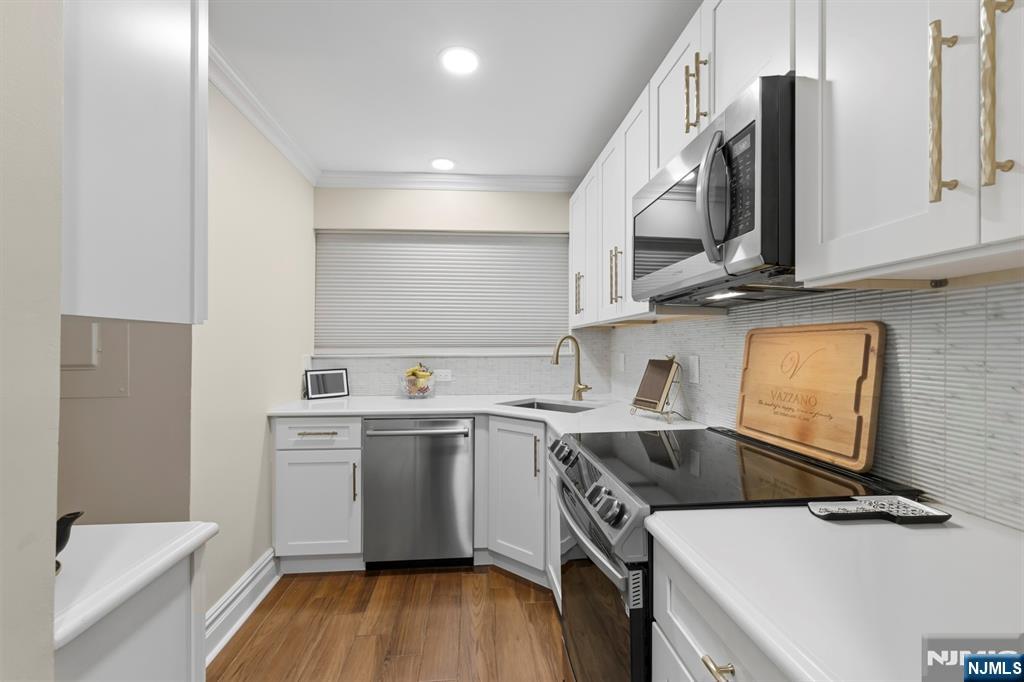 101 Highway 5, Unit 304 Edgewater, NJ 07020 - Photo 5 of 24 a kitchen with a sink a stove and cabinets