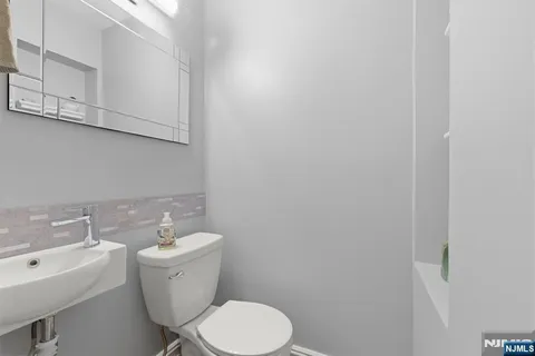 a bathroom with a toilet a sink and mirror
