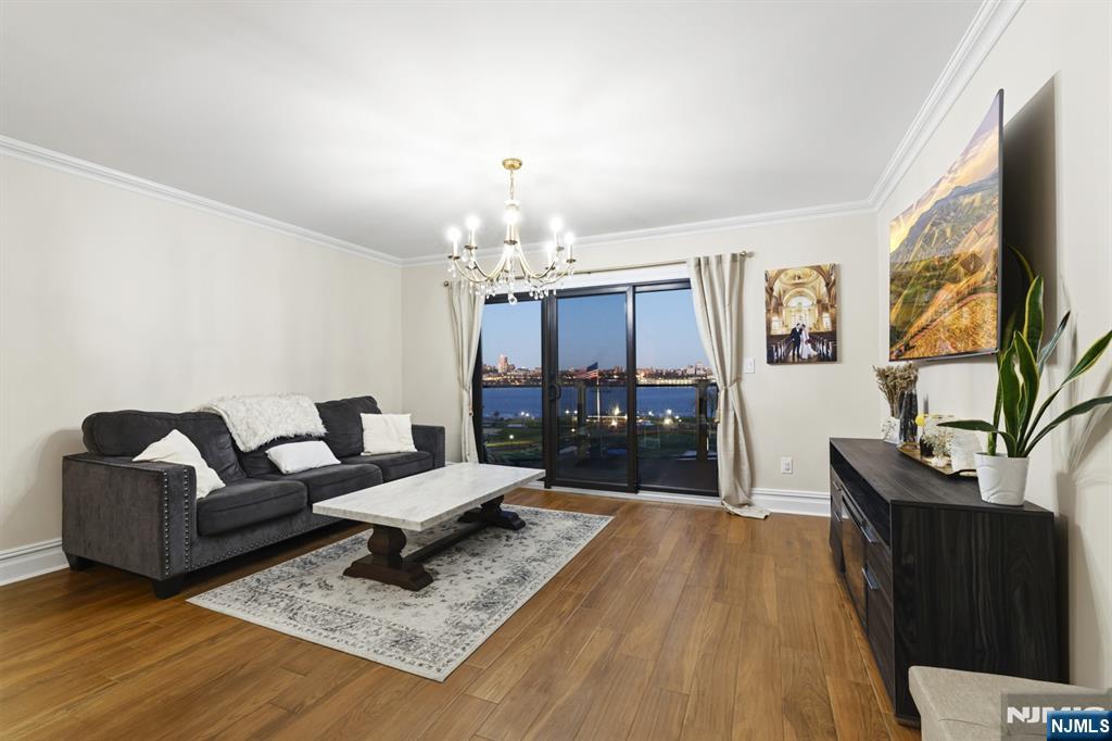 101 Highway 5, Unit 304 Edgewater, NJ 07020 - Photo 10 of 24 a living room with furniture and a chandelier