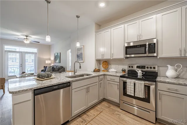 a kitchen with stainless steel appliances granite countertop a sink stove a microwave and cabinets