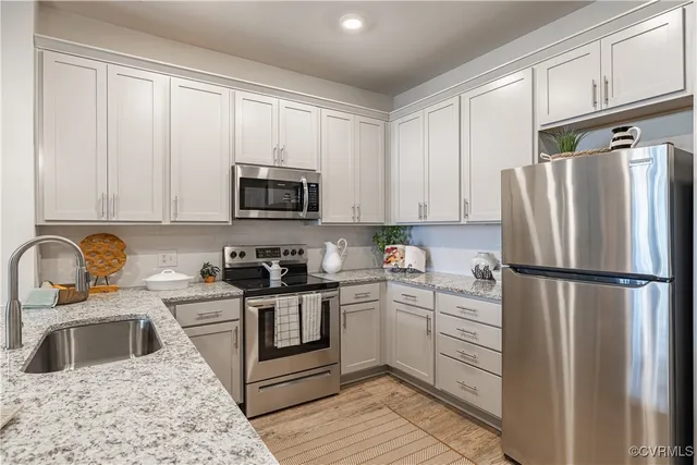 a kitchen with a refrigerator sink and white cabinets