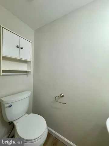 a white toilet sitting next to a shower