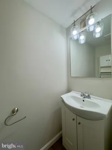 a bathroom with a sink a light fixture and a mirror