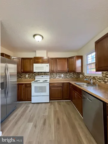 a kitchen with stainless steel appliances a refrigerator stove and kitchen island