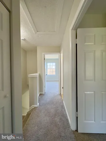 a view of a hallway with wooden shelves