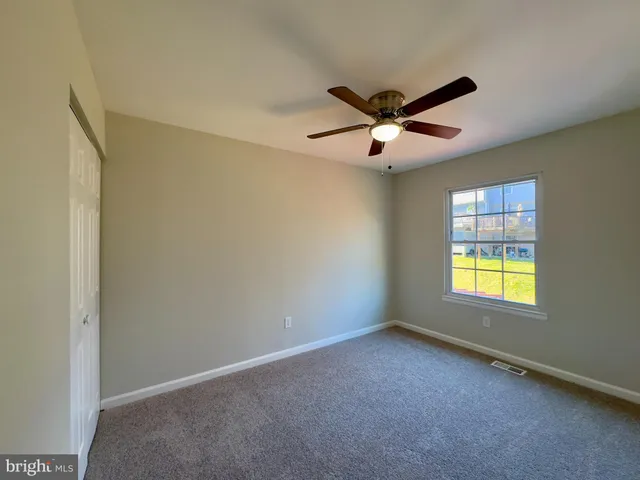 a view of a livingroom with a ceiling fan and window