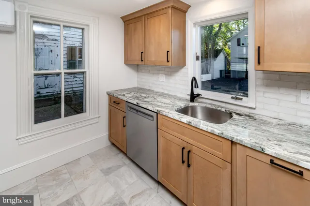 a kitchen with granite countertop a sink and white cabinets