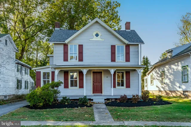 a front view of a house with a yard and trees
