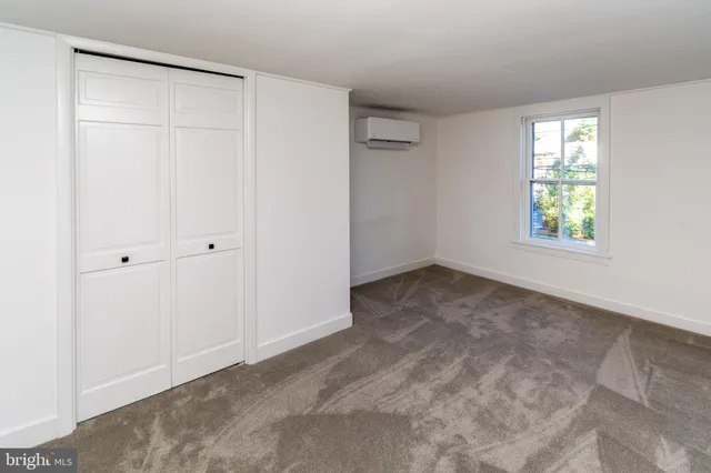 an empty room with windows and closet