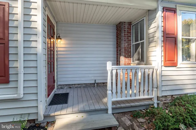 a view of a porch with wooden floor and a floor to ceiling window