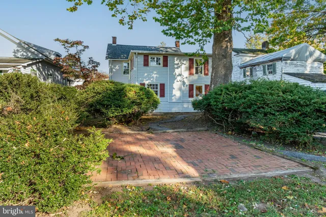 a front view of a house with a yard and a garden
